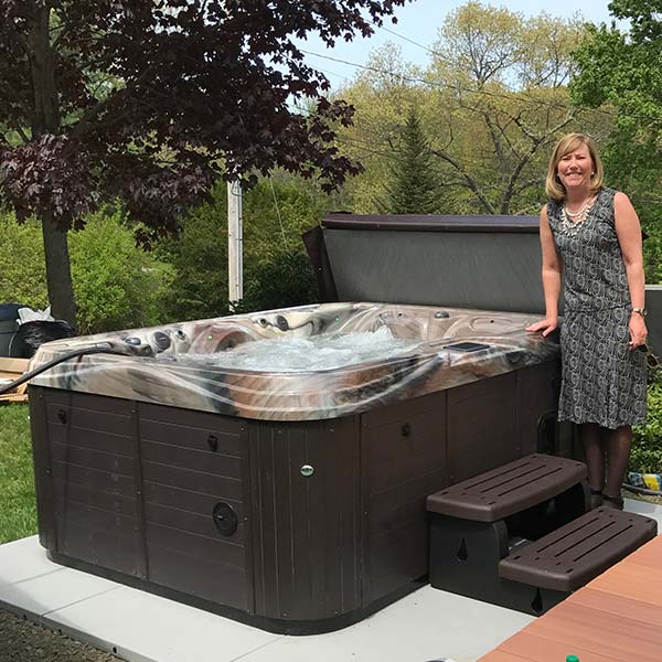 woman standing next to her new hot tub