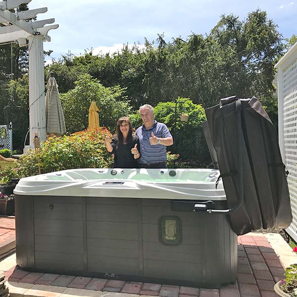 couple with thumbs up in front of new hot tub