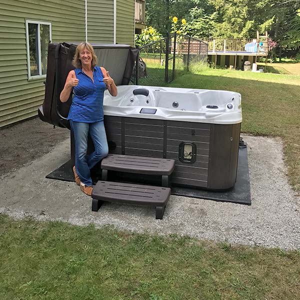 woman holding a thumbs up in front of new hot tub