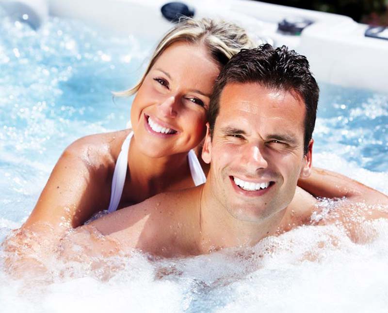smiling couple in a hot tub